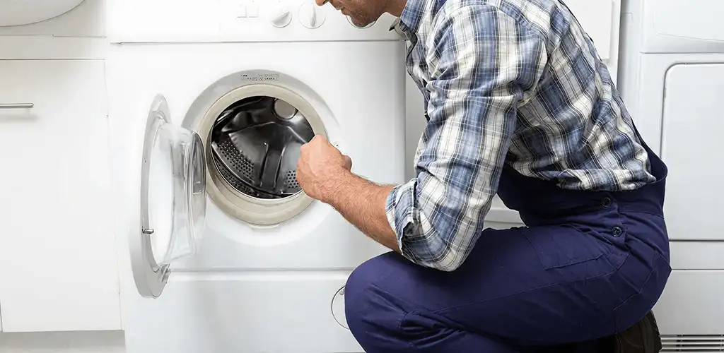 Handyman inspecting a dryer drum and internal parts for repair in Baton Rouge, LA