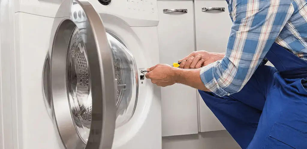 Handyman repairing a clothes dryer and checking electrical connections in Baton Rouge, LA