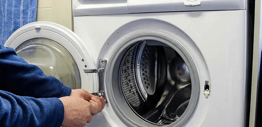 Washing machine repair handyman checking a front-load washer door and latch in Baton Rouge, LA